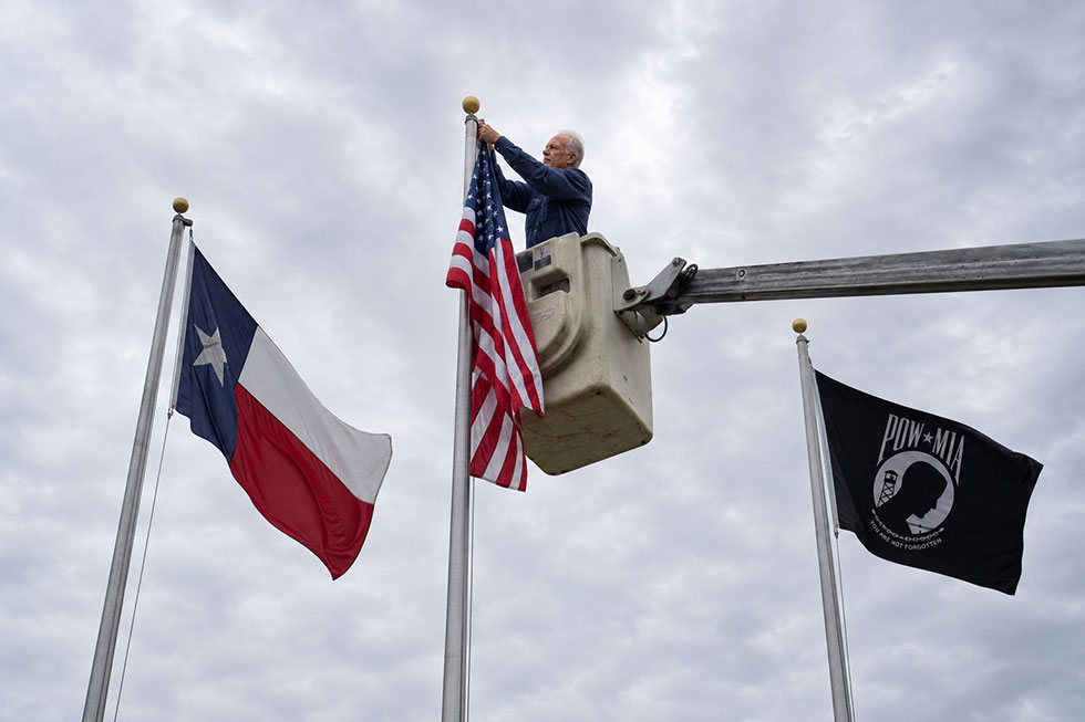 Robert Dixon of Flagmobile in Plano, Texas is in a cherry picker and replacing an American flag on a flagpole.